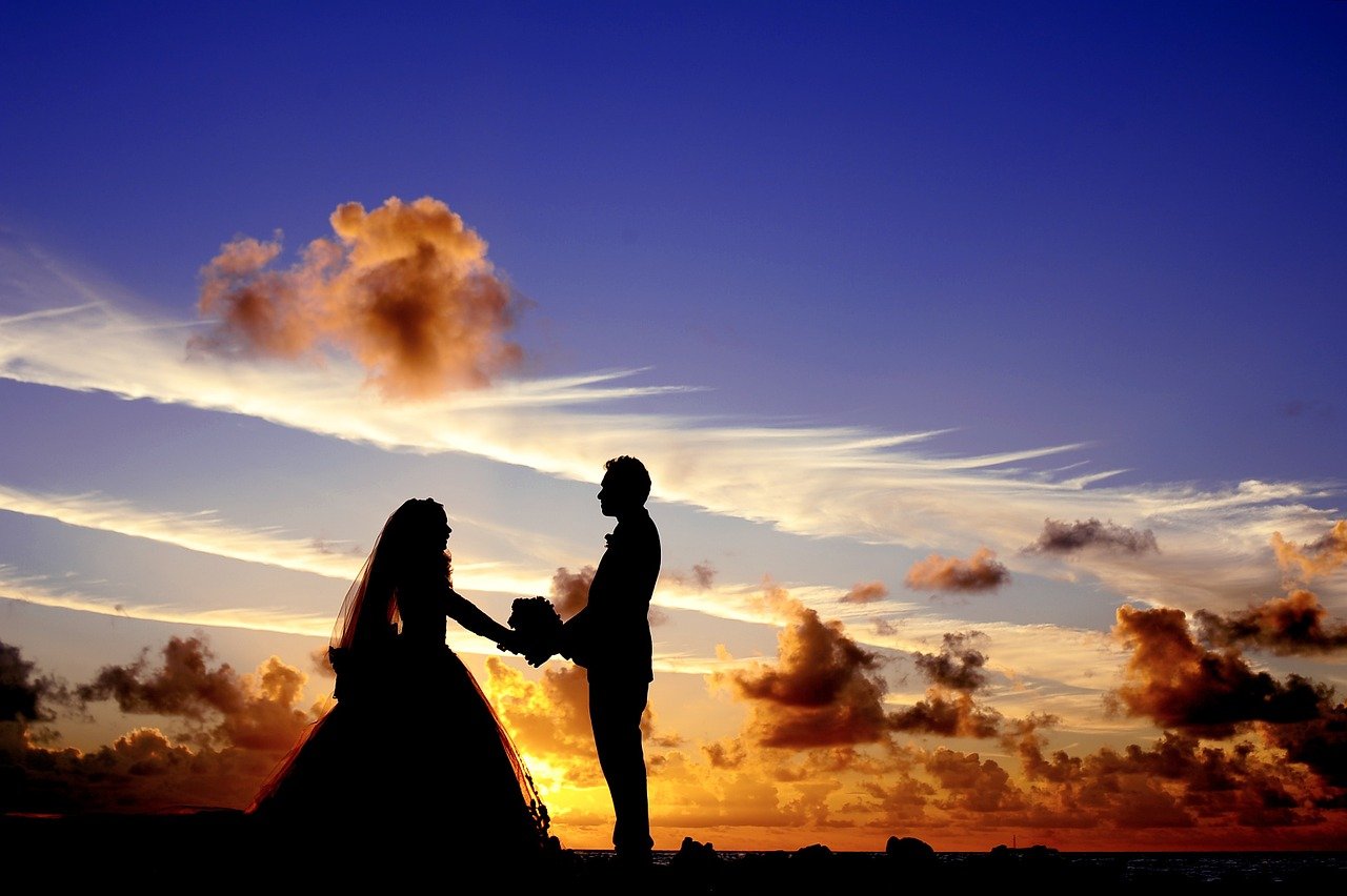 夕焼けと結婚する男女の画像